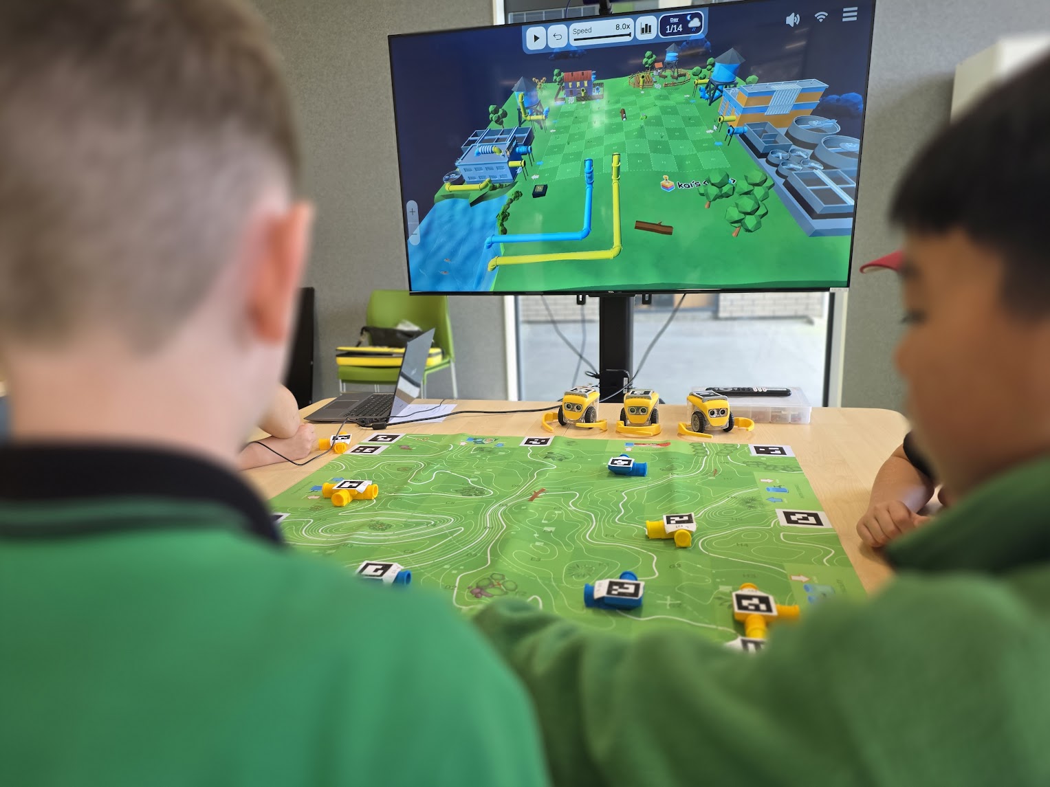 Students working on the Water Cycle AR VR mat in a classroom with KaiLab robots in the background